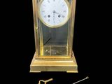 une horloge dorée avec un pendule sur fond noir