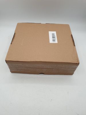 une boîte en carton sur laquelle est collé un autocollant, posée sur une surface blanche