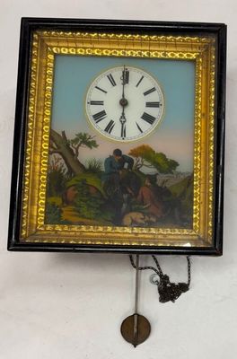 une horloge accrochée au mur, à côté d'un tableau représentant un homme et un chien