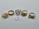five different rings and a price tag on a white surface