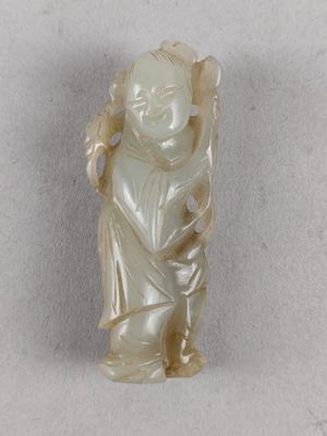 une petite statue représentant un garçon tenant un sac
