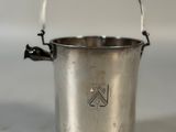 a small metal bucket with a handle on a table