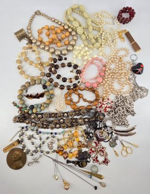 a close up of a pile of jewelry on a white surface