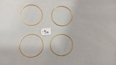 six bagues en or, accompagnées de leur étiquette de prix, posées sur une table