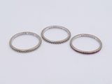 three silver rings on a white surface