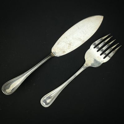 deux fourchettes et un couteau posés sur une table noire
