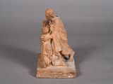 statue of a man holding a child on a wooden base