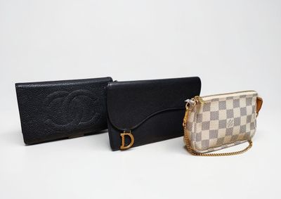 two purses and a wallet sitting on a white surface