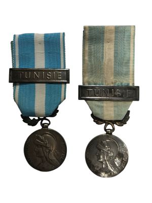 deux médailles sont représentées sur un fond blanc, accompagnées d'un ruban bleu et blanc