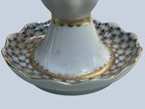 a white and blue vase with a gold trim on it