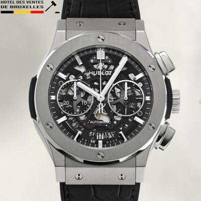 un gros plan d'une montre avec un bracelet noir sur fond blanc
