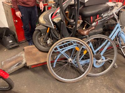 a man standing next to a pile of bikes in a garage