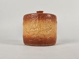un vase marron et orange avec un couvercle, posé sur une table