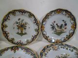 three plates with flowers and birds on them sitting on a table