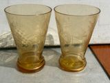 two glasses sitting on a table next to each other
