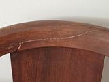 a close up of a wooden chair with a curved back