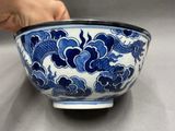 a person holding a blue and white bowl on a table
