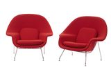 une paire de fauteuils « womb » rouges à pieds chromés