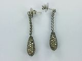 a pair of earrings with diamonds on them sitting on a white surface