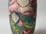 un vase vert orné d'un motif floral