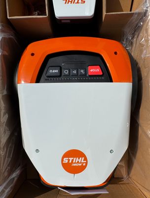 une machine orange et blanche posée dans une boîte, elle-même posée sur un carton