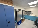 an image of a kitchen with a refrigerator and blue cabinets