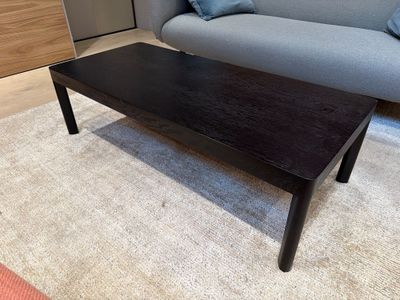 a black coffee table sitting on a rug in a living room