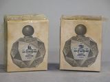 two boxes of perfume sitting on top of a table next to each other