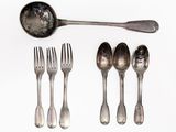 several spoons, forks, and spoon rest on a white surface