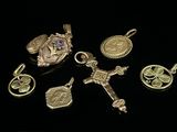 plusieurs breloques et pendentifs en or et en argent sur un fond noir