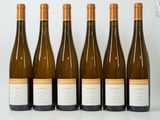 six bottles of wine are lined up on a table