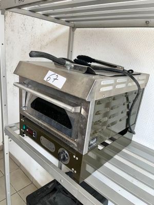 une photo d'un four grille-pain posé sur une étagère dans une cuisine
