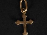 un pendentif en forme de croix en or sur fond noir