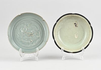 une paire d'assiettes bleues et blanches ornées de motifs, posées sur un support