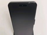 un gros plan sur l'arrière d'un téléphone noir posé sur une surface blanche