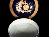 a blue and gold plate with a picture of a man and a woman on it