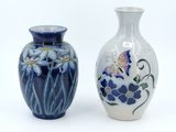 two vases sitting side by side on a white surface