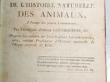 un vieux livre posé sur une table, à côté d'une plante