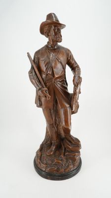 statue en bronze représentant un homme armé d'un pistolet et coiffé d'un chapeau