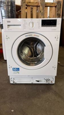 an image of a white washing machine sitting in a room