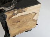 une statue représentant un homme assis sur un morceau de bois