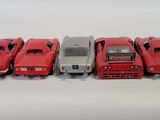 several toy cars are lined up in a row on a white surface