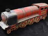 a red and black toy train sitting on a black surface