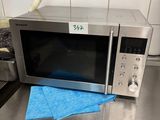 un micro-ondes posé sur un plan de travail recouvert d'un linge bleu