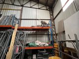 a room with a lot of metal shelves and a ladder