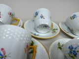 many cups and saucers that are sitting on a table