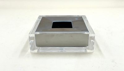 une petite boîte carrée en verre contenant un carré noir