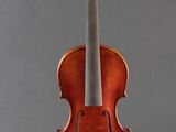 an old violin sitting on a stand against a gray background