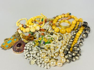 a pile of assorted jewelry on a white surface