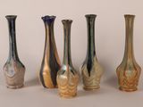 five different colored vases sitting next to each other